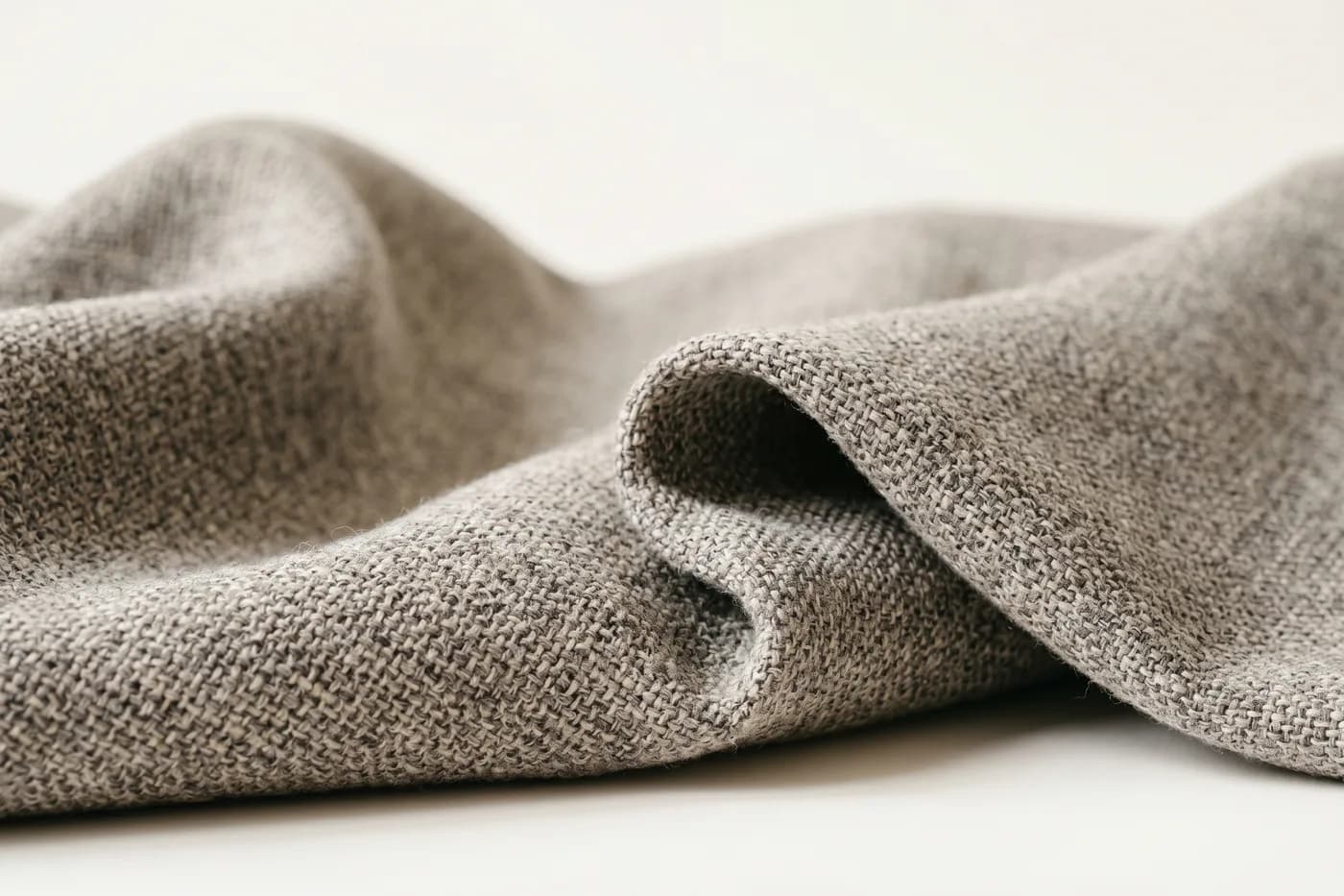 Draped hard-wearing upholstery fabric in a natural heather-grey weave