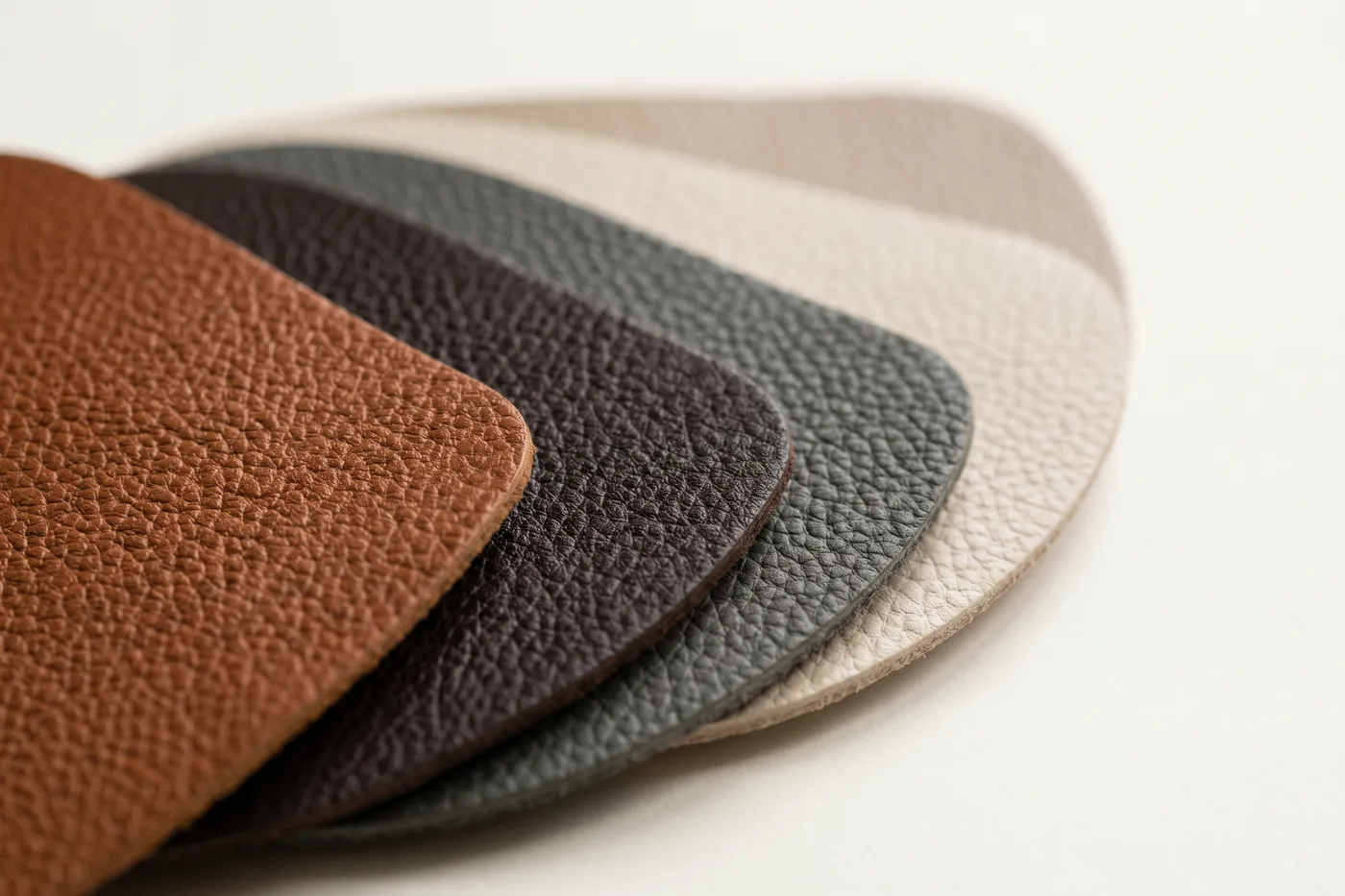 Fan of full-grain pebbled leather swatches in cognac, espresso, charcoal and cream